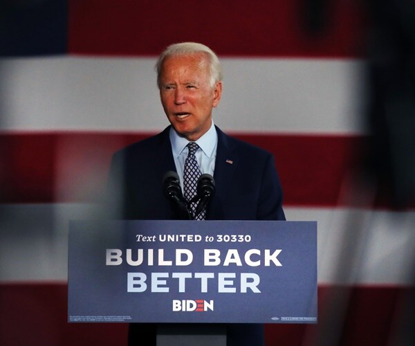 joe biden stands at a podium