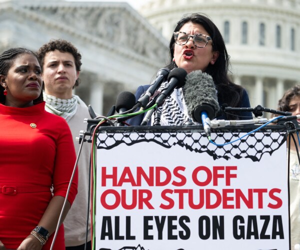 the congresswomen stand behind a sign reading hands off our students all eyes on gaza