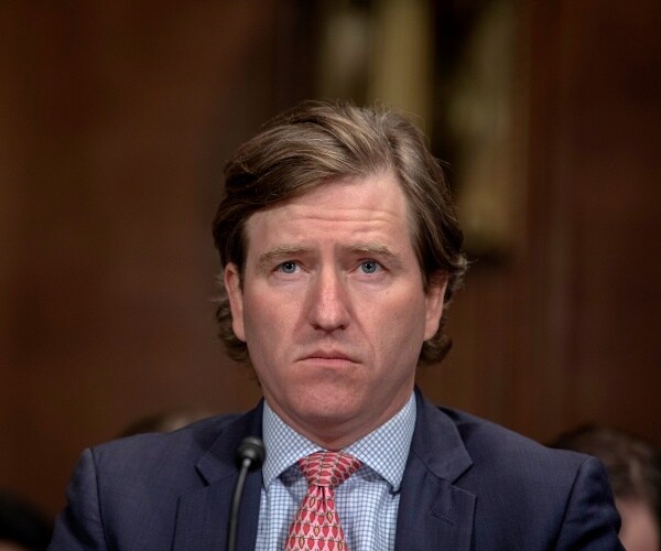 krebs in a suit and red patterned tie