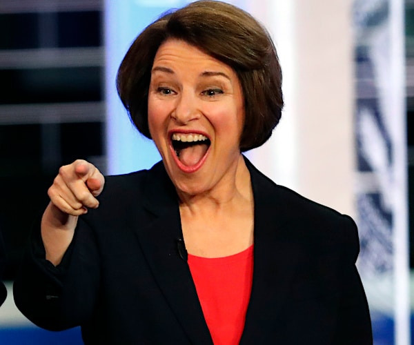 amy klobuchar points and smiles during a democratic presidential primary debate