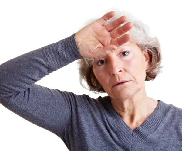 older woman with hand to head