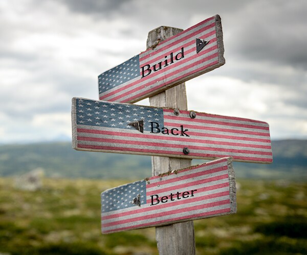 a trio of road signs pointing in different directions, reading build back better