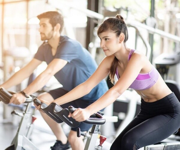 man and woman in a spin class