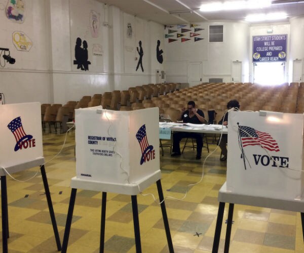 voter boxes sit in a high school auditorium