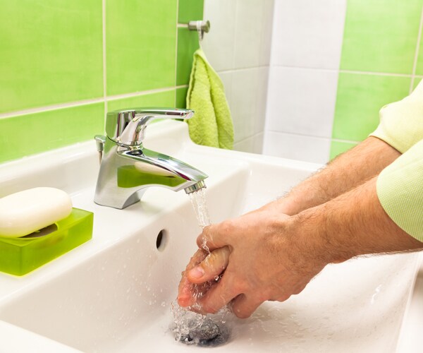 a person washes their hands in a sink