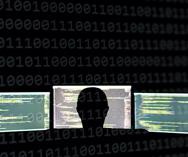 a hacker is shown in an illustration in front of computer screens