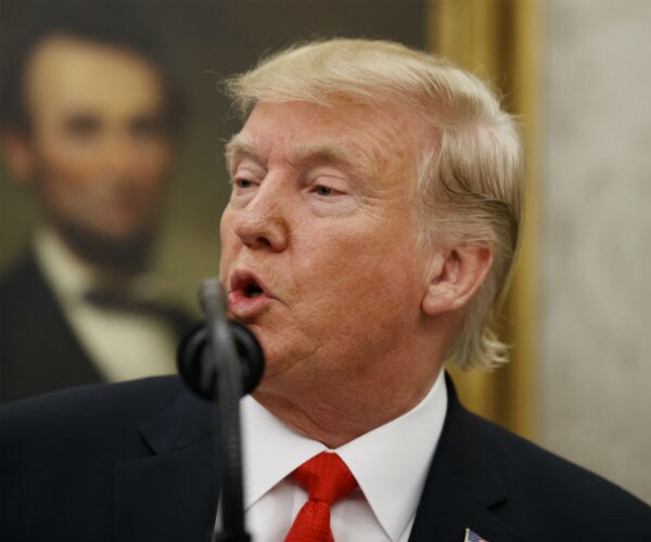 donald trump is shown in dark suit, red tie and white dress shirt