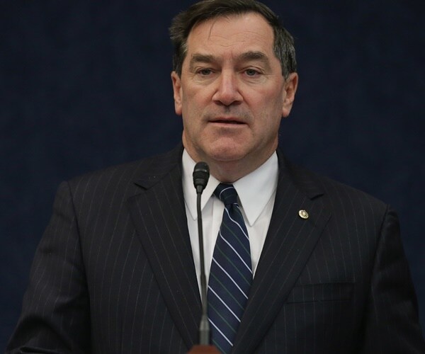 indiana democratic senator joe donnelly stands wearing a suit and tie