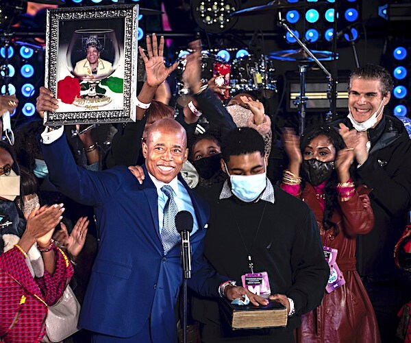 Eric Adams holds a portrait of his mother as he is sworn in as mayor of New York City on the stage Saturday