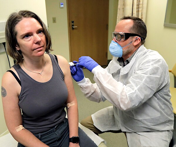 A pharmacist gives Jennifer Haller the first shot in the first-stage safety study clinical trial of a potential vaccine