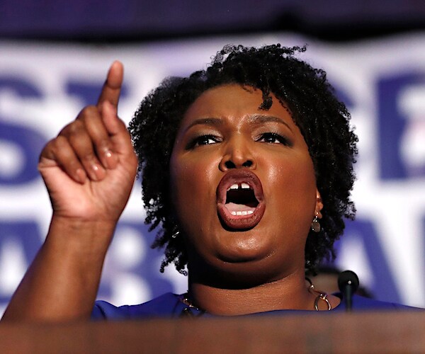 stacey abrams points and exults during a fiery campaign speech