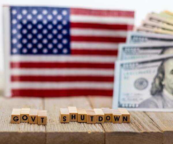 government shutdown us with american flag and money bills on white background and wooden board