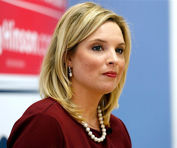 ashley hinson sits and listens during a campaign rally