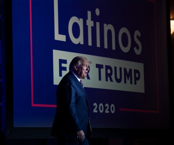 Donald Trump with latinos for trump in the background 