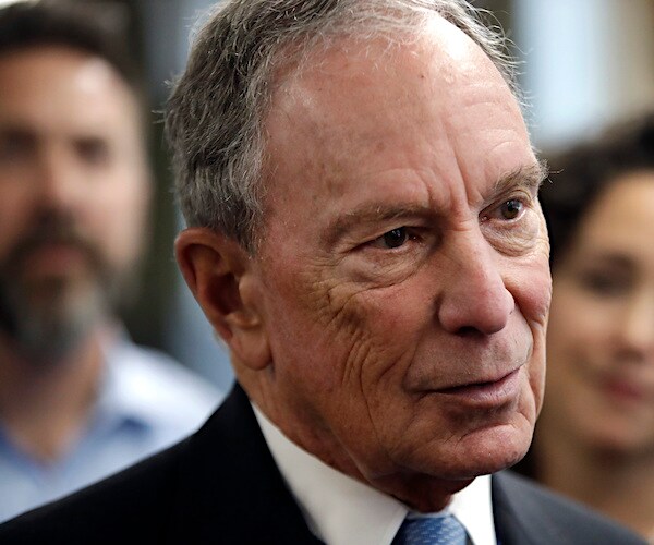 michael bloomberg tilts his head slightly to the side and speaks to the media