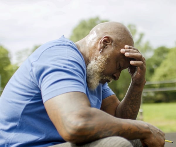 man looking depressed with head in hands