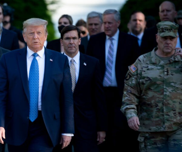 Mark Milley is shown walking along with Trump and other members in the trump administration in  combat fatigues