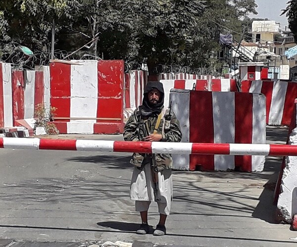 taliban soldier stands guard at gate