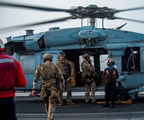 U.S sailors board a helicopter.