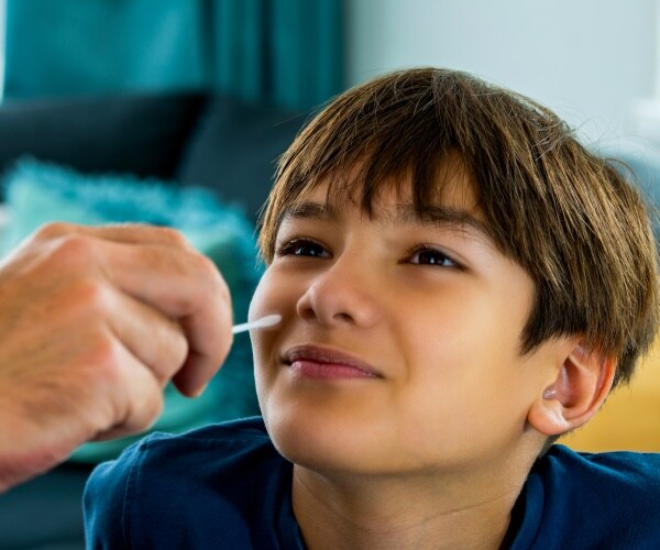 boy getting a nasal swab done at home