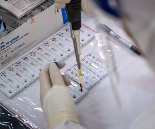 a medical technician handles a sample during a covid-19 test