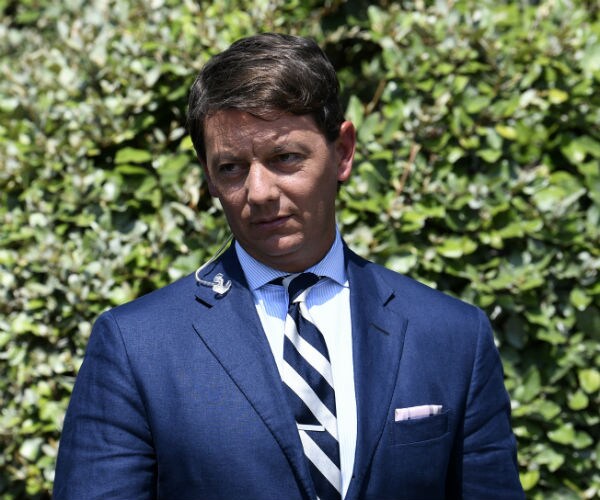 hogan gidley is shown outside the white house in blue suit, white dress shirt and blue and white striped tie