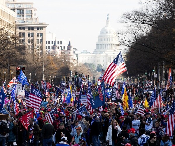 trump supporters fill the street leading to the capitol, waving flags and signs