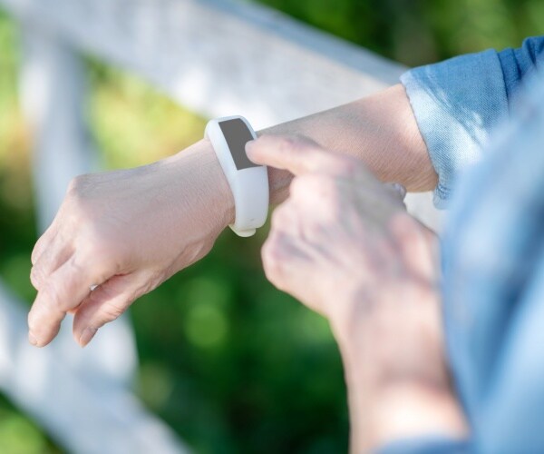 woman looking at her smartwatch during her walk