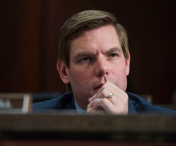 eric swalwell listens with his hands folder near his mouth