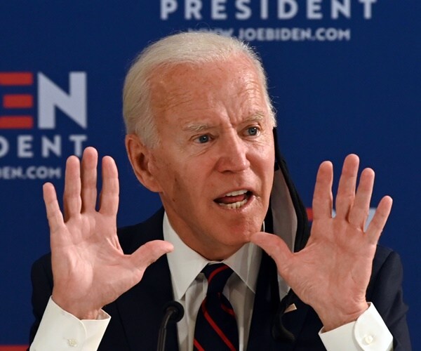 joe biden speaks at a meeting in front of biden wallpaper