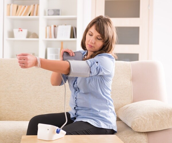 woman taking her blood pressure at home