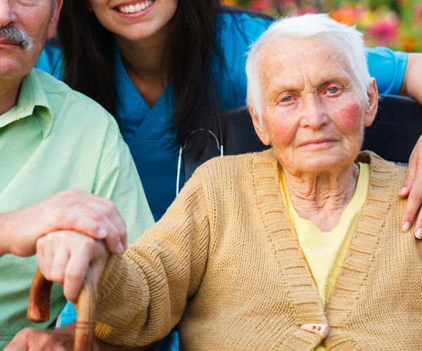 elderly women surrounded by family and doctor