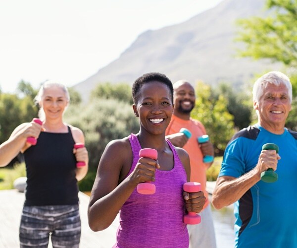 men and women outside exercising, smiling