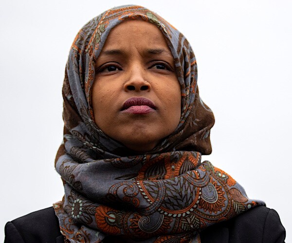 democratic minnesota representative ilhan omar wears a headdress and looks on pensively