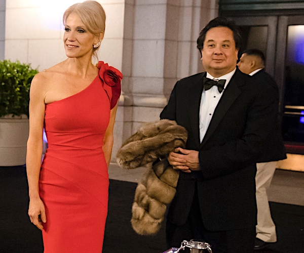 kellyanne conway's husband stands back and holds her coat as she arrives at a presidential event