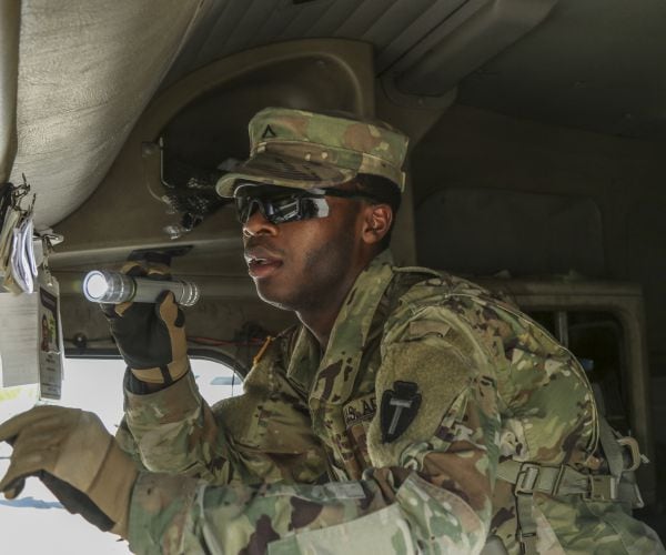 a guard searching through the cab of a semi-trailer as part of inspection operations.