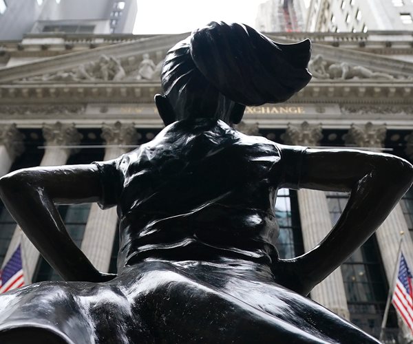 The Fearless Girl bronze sculpture by Kristen Visbal seen opposite the New York Stock Exchange