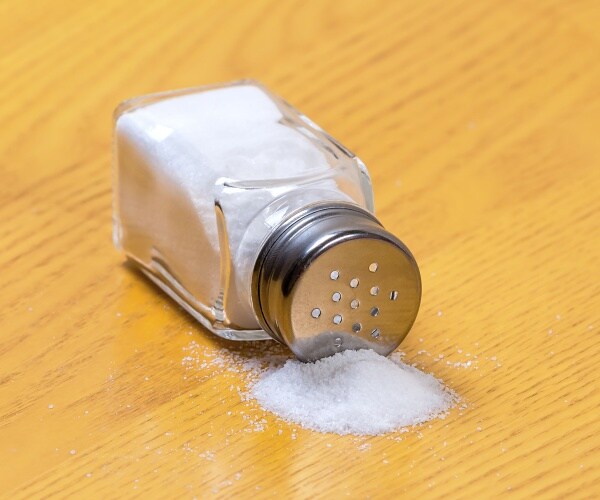 salt shaker on its side spilling out salt