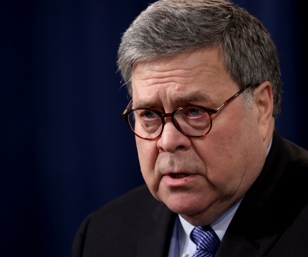 barr in a black suit and blue tie