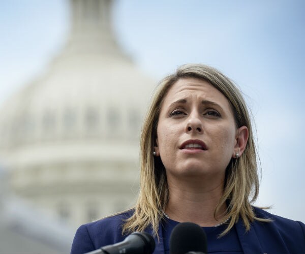 rep. katie hill speaks at a press conference with the us capitol building in the background