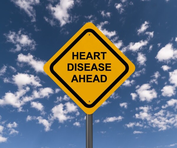 yellow caution road sign says 'heart disease'