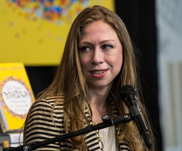 Chelsea Clinton speaking into a microphone at a book signing.