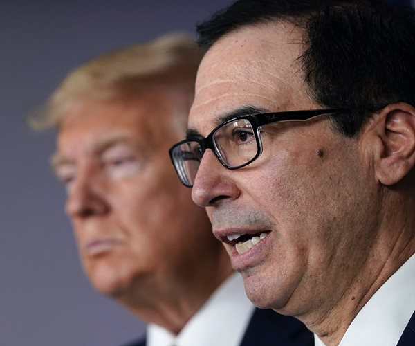 steven mnuchin in profile with donald trump behind him 