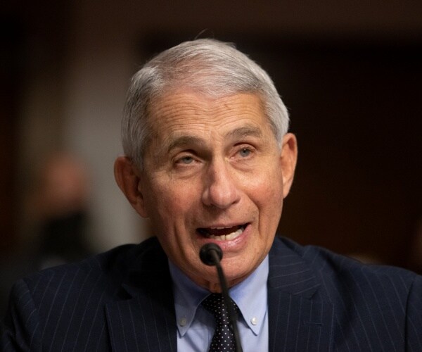 anthony fauci speaks into microphone