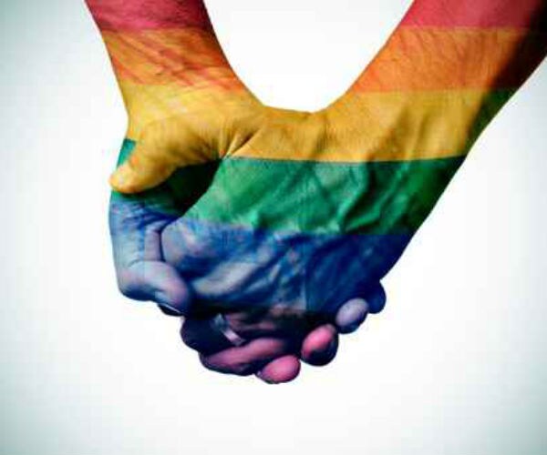 gay pride colors shown on the hands of a gay couple