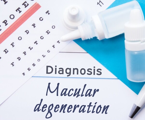 diagnosis pad says 'macular degeneration' with a pen and some eyedrops and eye chart