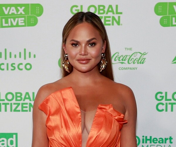 chrissy teigen stands on red carpet