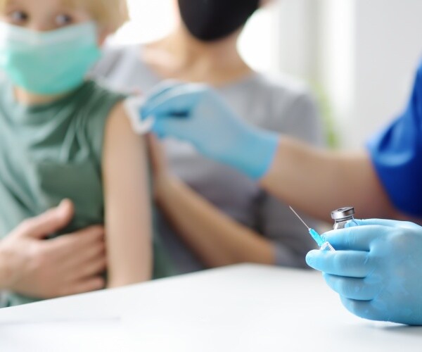 Young boy looks fearful as he gets a shot