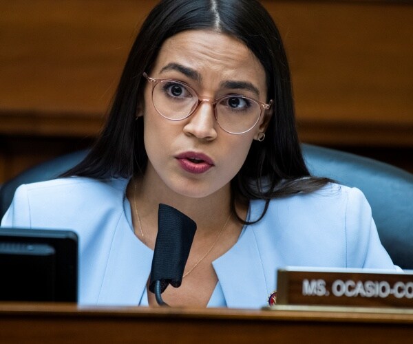 alexandria ocasio-cortez speaks from her seat i the committee room