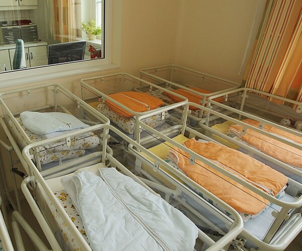 empty baby cribs sit in a maternity ward.